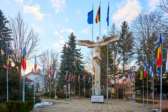 Statue and international flags display in outdoor park setting. March 3, 2026, Suceava Romania