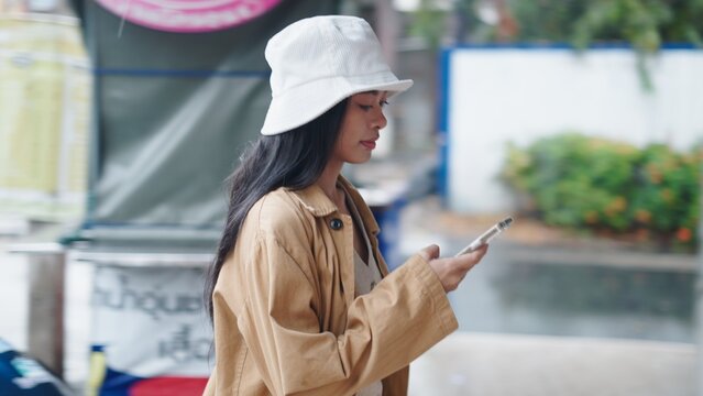 Young woman using smartphone outdoors, engaging with digital content
