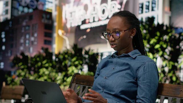 Upset digital nomad girl struggling to work on laptop in the park, barely meeting deadlines. Worried remote worker doing freelancing outside, using notebook and feeling burnout, bad news.
