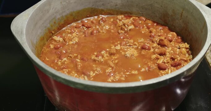 Thick chili con carne simmering in a large pot