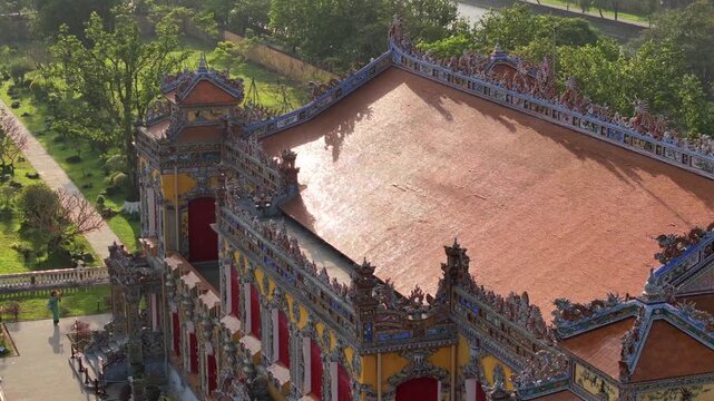 Kien Trung Palace in Hue Imperial City with a vibrant yellow facade, red shutters and roof details. Aerial Drone Shot