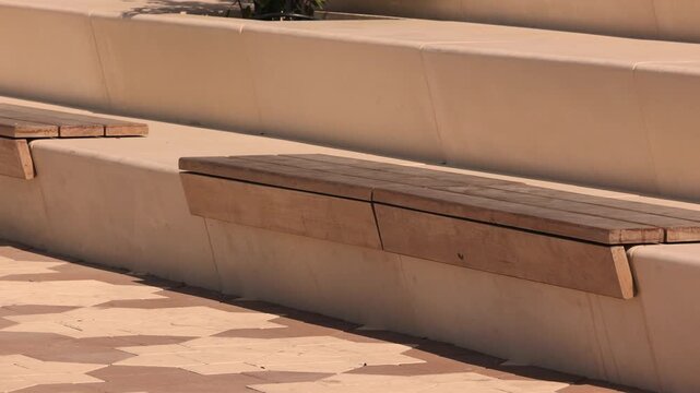 Modern urban street seating wooden bench integrated into city infrastructure