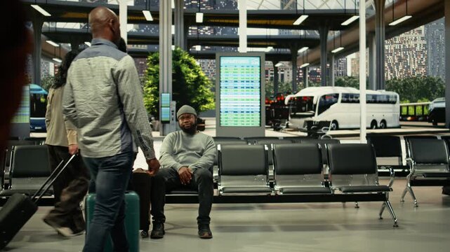 Time lapse of bus terminal with people preparing for international and regional route. Travelers carrying luggage and trolley bags gather in the waiting area, checking long-haul journey details.