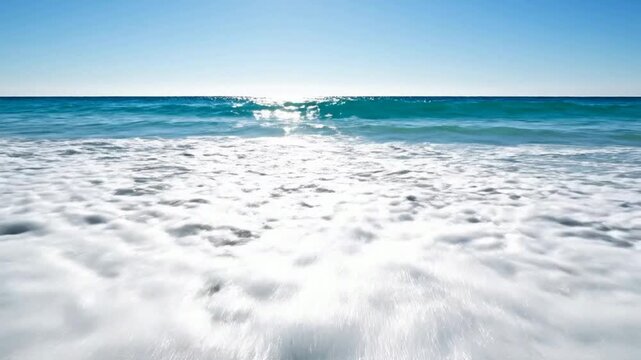 Crystal clear ocean wave crashing on tropical sandy beach shoreline in slow motion