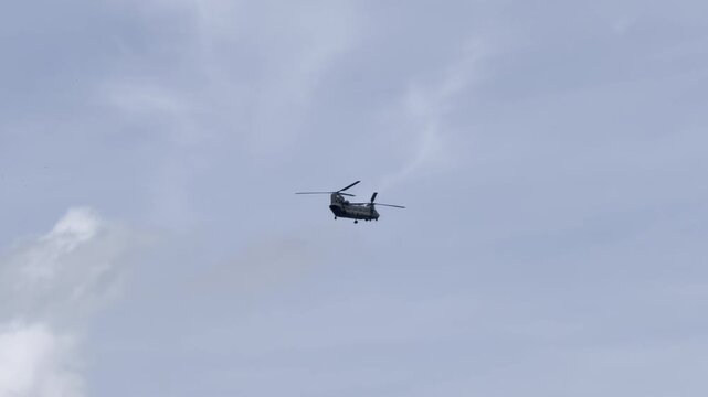 Large chinook flying through cloudy sky aerial