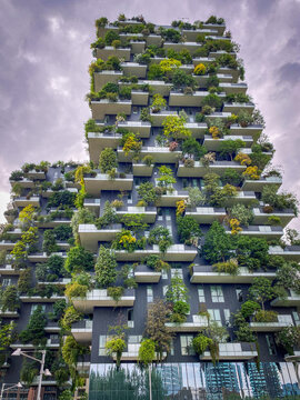 Milan, Italy - May 18, 2023: Bosco Verticale towers showing sustainability in modern high-rise architecture with trees and plants on balconies against a cloudy sky