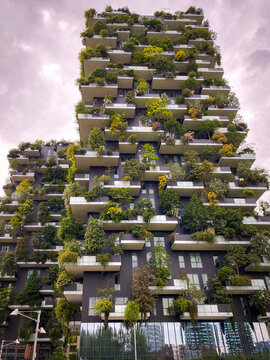 Milan, Italy - May 18, 2023: Bosco Verticale towers showing sustainability in modern high-rise architecture with trees and plants on balconies against a cloudy sky