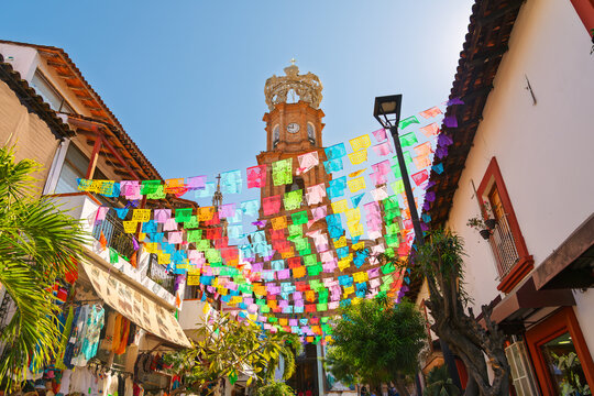 The Parish Church of Our Lady of Guadalupe decorated with colorful papel picado flags and topped with a crown in the Romantic Zone neighborhood of Puerto Vallarta, Mexico.