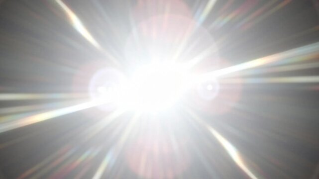 Abstract bright white light burst with radial rays on dark background.