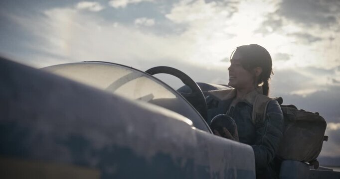 Dirt covered woman driving sci-fi vehicle and talking - low, silhouette shot