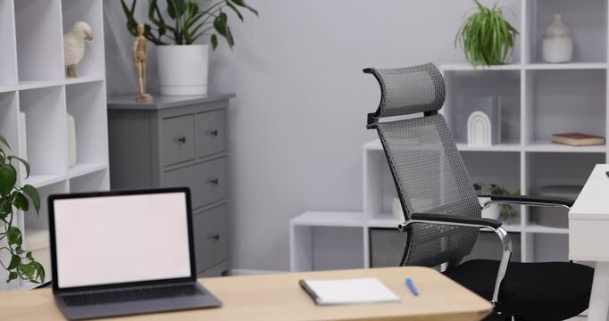 Interior design. Desks with laptops, stationery, other furniture and decor. Camera moving right