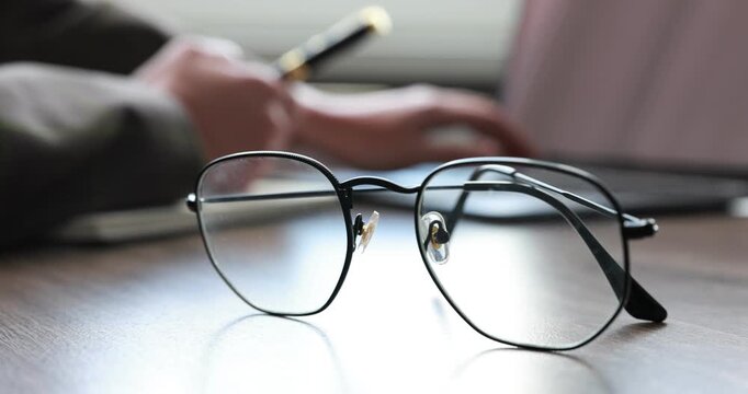 Businesswoman working with laptop at table, focus on stylish glasses