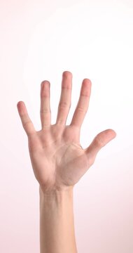 Woman counting on fingers against white background, closeup