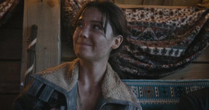 Filthy, happy woman sitting in cabin - medium shot