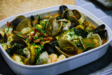 Clams and mussels cocked in a ceramic dish. © Ivan