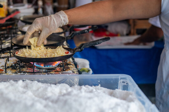 Rio de Janeiro, Brazil - 22 May 2026: View of a street food vendor preparing traditional tapioca with cheese in a small frying pan over a gas flame at Square Nossa Senhora da Paz.