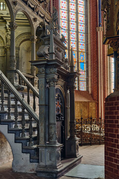 Bad Doberan, Germany - 19 July 2025: View of the ornate interior of Doberaner Munster featuring a decorative staircase, intricate sculptures, and a stained glass window.