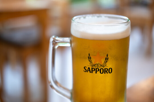 Bangkok, Thailand - 5 December 2025: A mug of Sapporo, an oldest brand of beer in Japan.