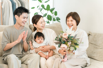 A granddaughter and her three-generation family present a bouquet of flowers to their grandmother on Respect for the Aged Day and her birthday.