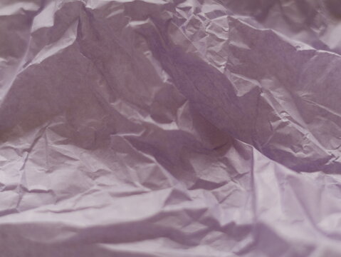 Una toma de cerca de un fondo abstracto de un papel arrugado  color violeta brillante con un degradado ligero desenfocado	