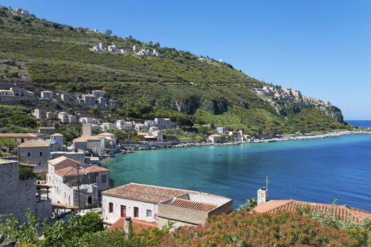 Picturesque view of a Mediterranean coastal village on a sunny day with traditional houses and a clear blue sea, Limeni, Areopoli, Laconia, Peloponnese, Greece