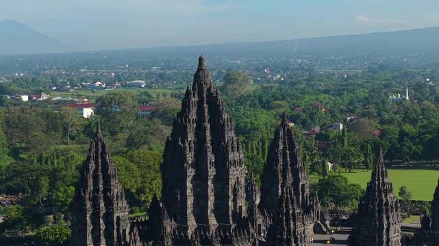 Aerial view of the ancient Prambanan Temple complex with its towering stone spires surrounded by lush tropical greenery in Kecamatan Prambanan, Daerah Istimewa Yogya, Indonesia.