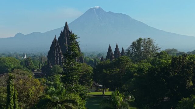 Aerial view of the ancient Prambanan Temple spires surrounded by lush greenery with Mount Merapi in the background, Kecamatan Prambanan, Daerah Istimewa Yogya, Indonesia.