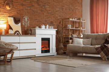 Obraz premium Interior of stylish modern living room with fireplace, sofa and commode near brick wall
