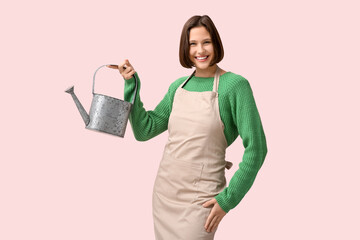 Beautiful young woman with stainless steel watering can on pink background © Pixel-Shot
