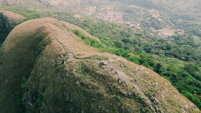 Amedzofe, Ghana - 22 May 2026: Aerial view of Mt. Gemi with hikers on the ridge overlooking the lush green hills and the village in the Volta Region.