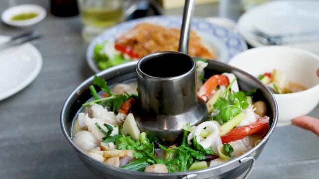 Traditional Thai Tom Yum Seafood Hot Pot Served in Metal Pot
