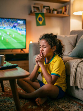 Crian&ccedil;a brasileira rezando durante jogo de futebol