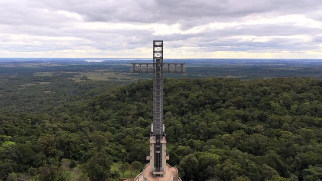 Parque Tem&aacute;tico de la Cruz in Santa Ana Misiones Argentina featuring monumental steel cross tower above Upper Paran&aacute; Atlantic Forest landscape and subtropical rainforest canopy, drone static