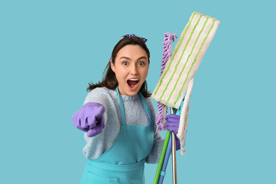 Cheerful woman with different mops on blue background
