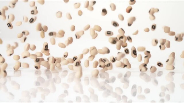 Southern New Year good luck Black Eyed Peas bouncing on a white tabletop in slow motion close up macro before settling.