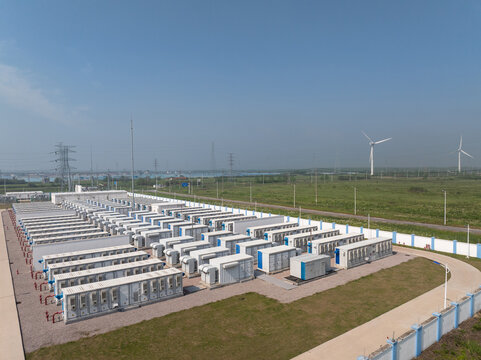 Outdoor energy storage power station containers and wind turbines under blue sky