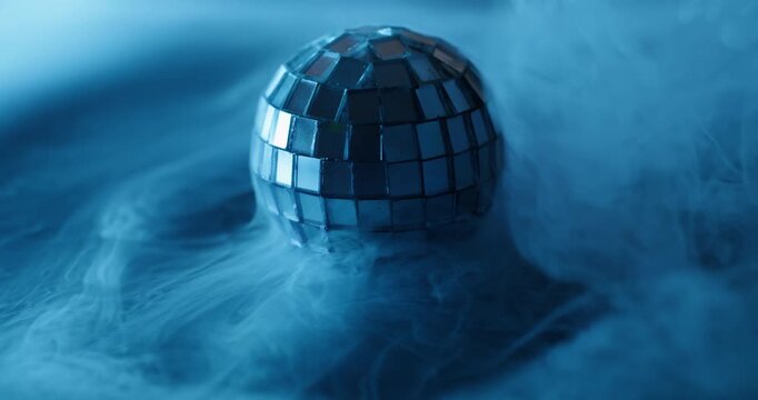 Disco ball. Blue water vapor. Defocused cold color splash gleam round texture scratched glass smoke cascade on abstract art light background.