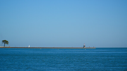 Obraz premium Landscape A long breakwater stretching into Lake Michigan with the Chicago Harbor Lighthouse at the far right.