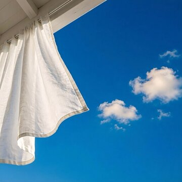 ​初夏の爽やかな青空、心地よい風に揺れる白いリネン布と明るい日差しが差し込む背景素材