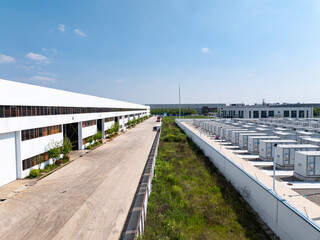 Naklejka premium Industrial park in Nantong with white factory buildings and energy storage units under blue sky