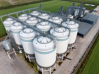Aerial view of large white grain silos for agricultural storage and industrial logistics © zhu difeng