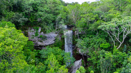 A majestic waterfall cascades through dense greenery, showcasing vibrant foliage and rugged rock formations in Colombia's natural landscape. © Jhampier Giron