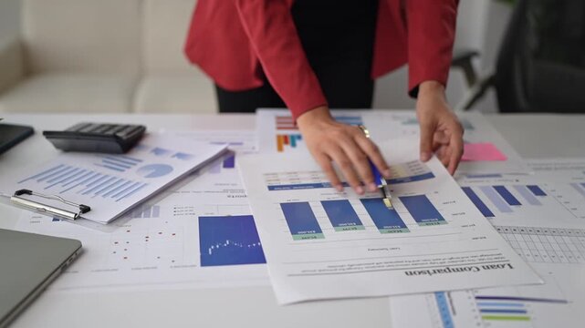 Businesswoman analyzing financial reports and charts