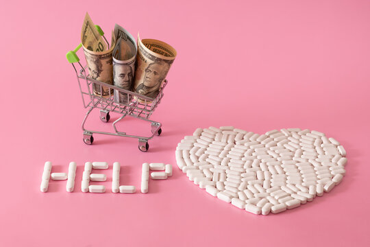 A symbolic human heart, assembled from white pills and several US dollar bills on a pink background