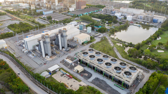 Industrial Power Plant: An aerial view showcases a sprawling industrial power plant with its complex machinery and cooling towers, symbolizing modern infrastructure and energy production.