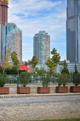 Obraz premium City Skyline Meets Tranquil Waters. Peaceful Promenade With Urban Skyline Backdrop new york