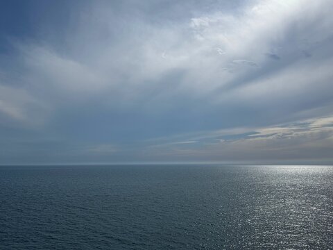 Calm sea blue glittering surface and beautiful cloudy sky.