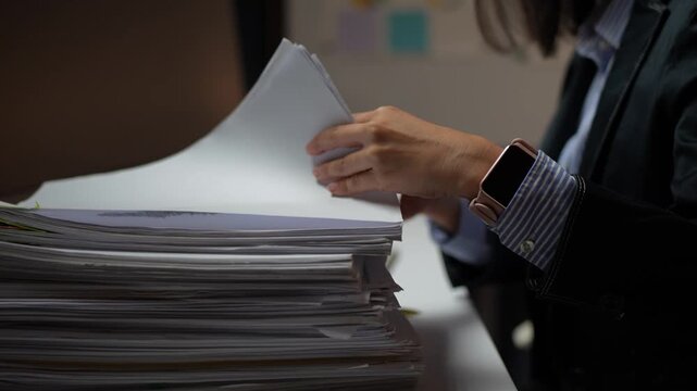 Businesswoman searching through a stack of paperwork