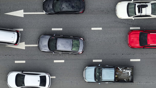 Aerial drone captures heavy traffic congestion and delays on an asphalt road, highlighting urban congestion, time loss, environmental impact, urban planning, transport challenges and modern city life.