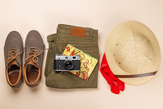 Safari clothing and gear on beige background